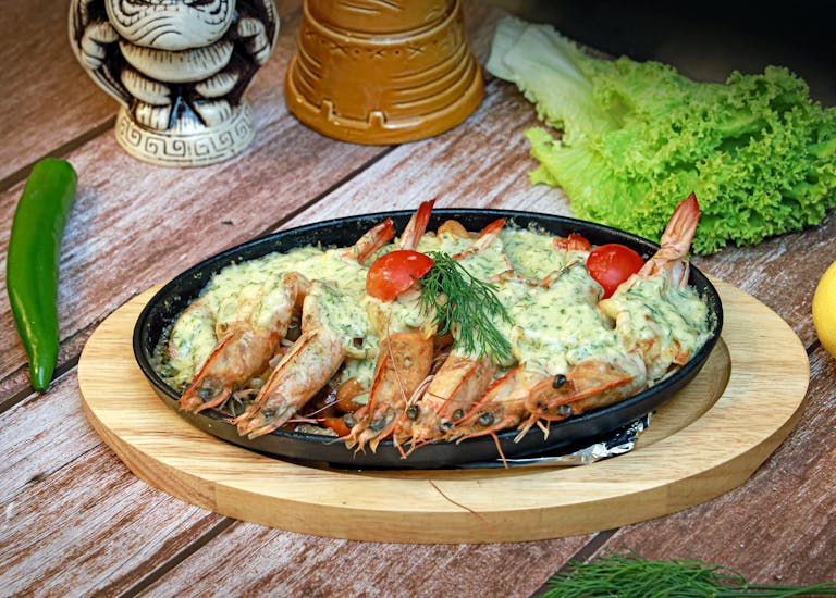 Delicious seafood platter featuring herb-crusted shrimp with cherry tomatoes, garnished with fresh dill.