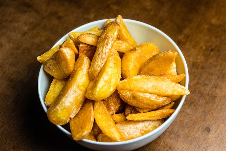 Enjoy delicious homemade golden french fries served in a classic white bowl.